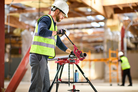 Construction worker cutting pipe